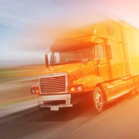 A blurry red and orange truck on road.